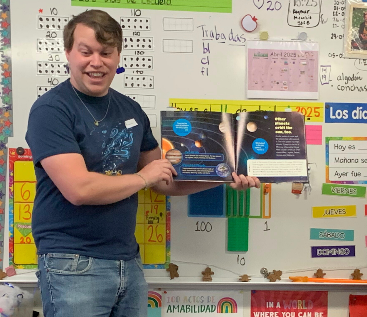 Eli reading an astronomy book to elementary students